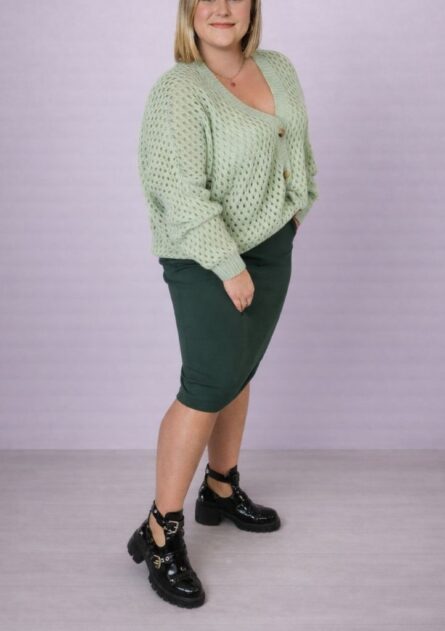 Sweter damski over rozpinany ażurowy miętowy PatiStyle. Luźny i z bardzo miłego materiału sweter z ozdobnymi brązowymi guzikami. Spódniczka damska midi z prążka zielona PatiStyle. Piękna, elastyczna i wygodna spódniczka - idealna baza wielu stylizacji.